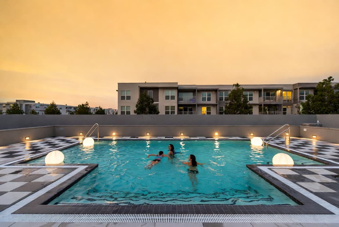Families swimming at HOA pool at sunset