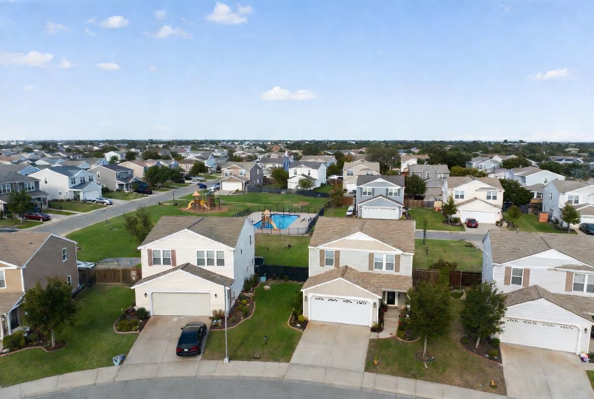Aerial view of residential HOA neighborhood with community pool and playground