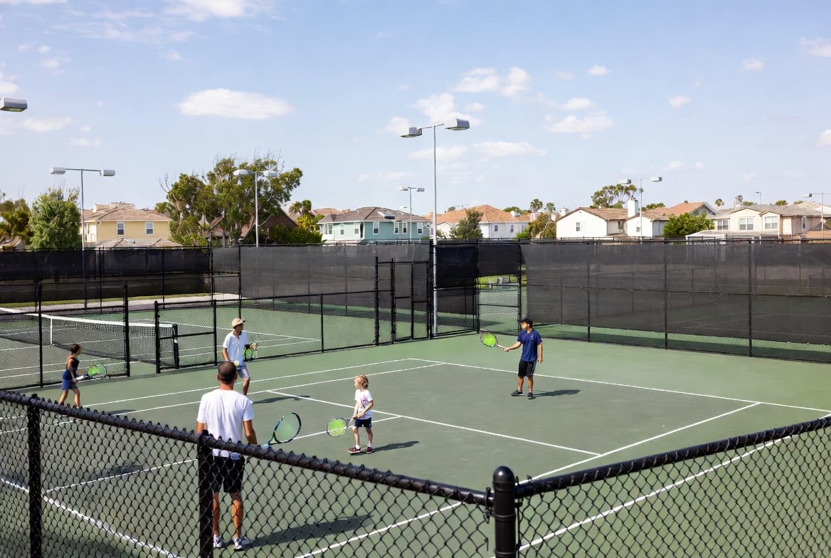 Families using HOA tennis courts in a residential neighborhood