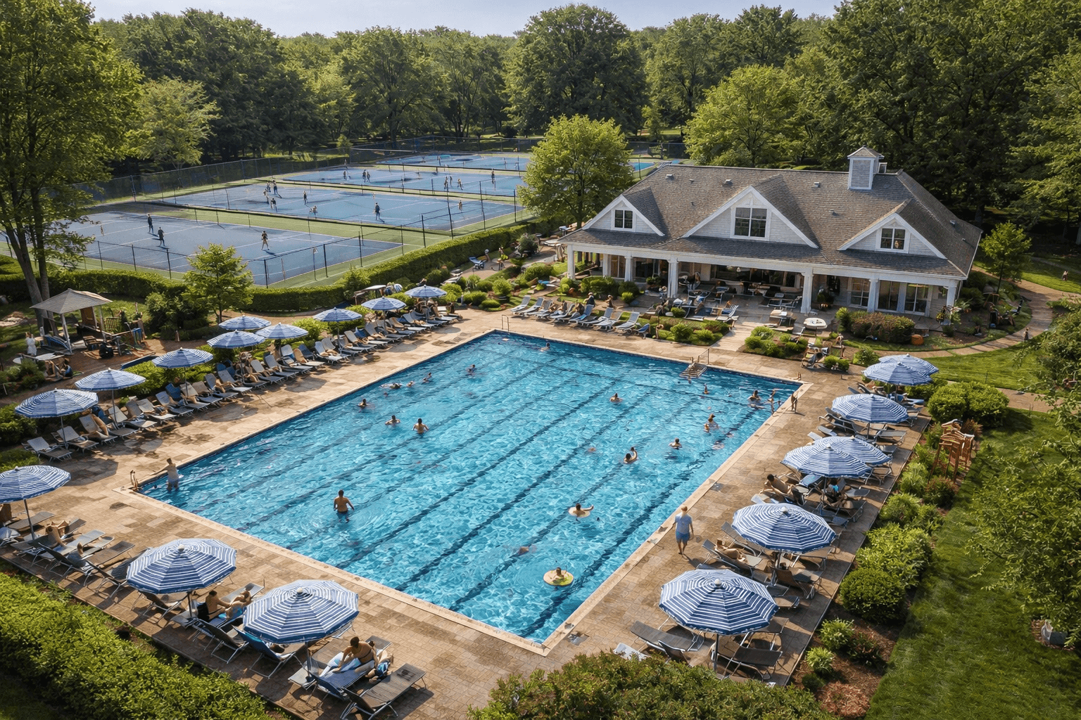 Aerial view of a swim and tennis club with a pool, clubhouse, and courts.